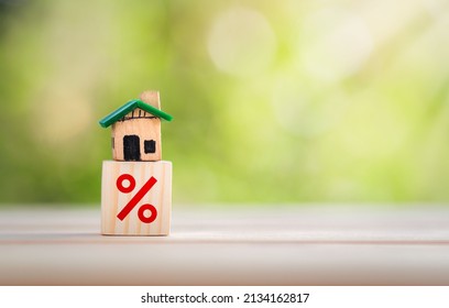 Interest rate financial and mortgage rates concept. House is placed on a wooden block with interest or tax rates,Mortgage rates business concept of investment real estate interest rates home appraisal - Shutterstock ID 2134162817