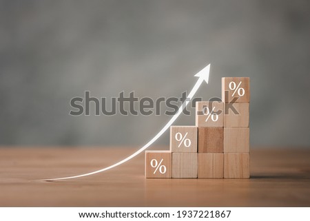 Interest rate financial and mortgage rates concept. Wooden blocks with Icon percentage symbol and arrow pointing up. The economy is improving.