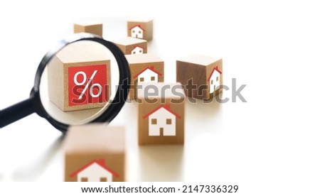 Interest rate financial and mortgage rates review concept. Wooden cube blocks with percentage symbol, house icon and and magnifier