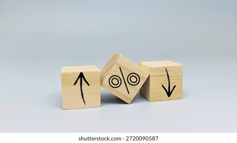 Interest rate increase or decrease concept with up and down arrows and percentage symbol on wooden blocks for financial crisis or economic growth. 