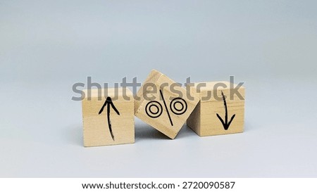 Interest rate increase or decrease concept with up and down arrows and percentage symbol on wooden blocks for financial crisis or economic growth. 