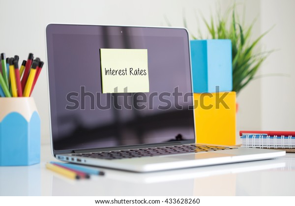 Interest Rates\
sticky note pasted on the\
laptop