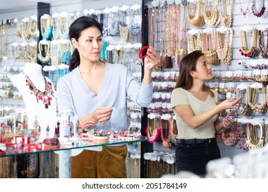 Interested Asian Woman Choosing Stylish Bracelet In Costume Jewelry Store..