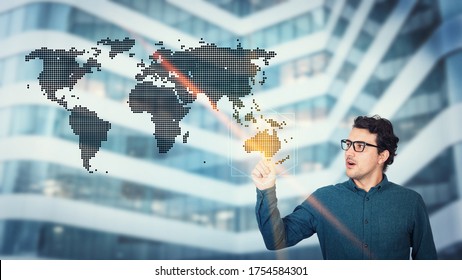 Interested Businessman Pointing Index Finger To A Digital World Map, Choosing Australia For Implementing His Future Plans. Business Presentation And Marketing Process. Man Demonstrate A New Project.