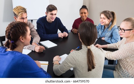 interested classmates having difficult project to complete during class sits by the table