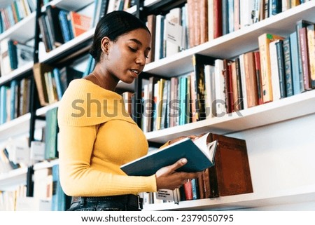 Interested ethnic student reading textbook in library