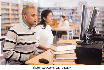 Interested Latin American Man Studying In Computer Class In Public Library..