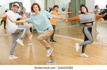 Interested Modern Teen Boys And Girls Practicing Dynamic Boogie-woogie In Pairs During Group Class In Dance Studio For Youth