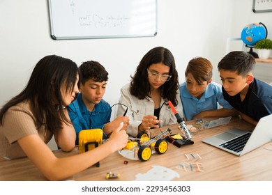 Interested smart teen students doing a collaborative project and teamwork during a robotics class and making a prototype