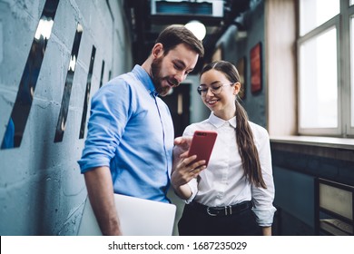 Interested smiling staff in trendy formal shirts and eyeglasses with documents using mobile in corridor of modern office with contemporary interior - Powered by Shutterstock