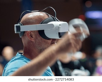 Interested visitor with VR goggles at the stand - Shutterstock ID 2272714083
