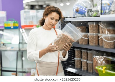 Interested woman visiting store to buy quality nutritious pet turtle food, reading ingredients on treat packages and contemplating choice.. - Powered by Shutterstock