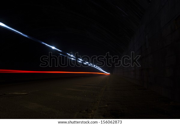 Interesting art lights from an ambulance in red,\
blue and white in a road\
tunnel