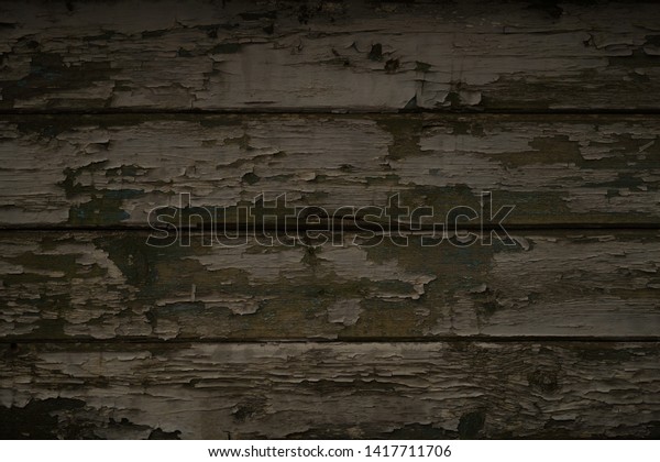 \
Interesting gloomy background of old dark\
shabby wooden boards. Trailing old paint on the surface of the\
boards. Old wooden painted dark boards. Old wooden painted dark\
boards. Vintage\
background.