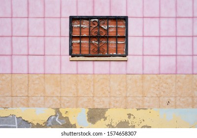 Interesting And Unusual Architecture And Color Choices. Tacky Pink And Orange Tile Wall With A Rustic, Mortar Window, In An Abandoned House.