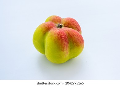 The Interesting, Unusual, Strange Apple. An Ugly Apple Surrounded By Ordinary Ones. The Photo Symbolizes Individuality, Leadership, Personal Characteristics, Self-acceptance.