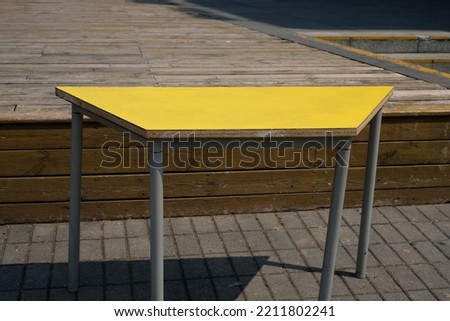 An interesting yellow trapezoid table outdoor.  Foto stock © 