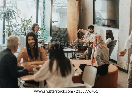 Inter-generational, multi-ethnic business group solving project problems together while working at modern co working space