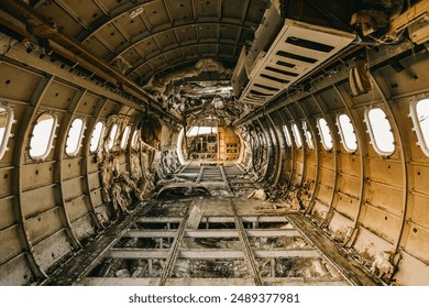 The interior of an abandoned airplane fuselage with structural damage and decay. - Powered by Shutterstock