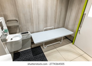 Interior of an accessible restroom featuring a multipurpose changing bench and ostomate facilities
