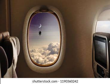 The interior of an airplane flying in the sky and outside the town of the window shows the silhouette of a woman on a swing hanging from the moon. Concept of: dreams, flying, freedom.