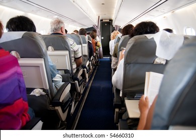 Interior of airplane with passengers on seats - Shutterstock ID 54660310