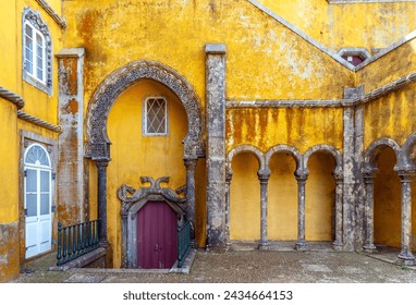 Interior of the arched courtyard with beautifully decorated arches and columns in Arabic style and the yellow painted walls of the Pena Palace in Sintra, Portugal. - Powered by Shutterstock