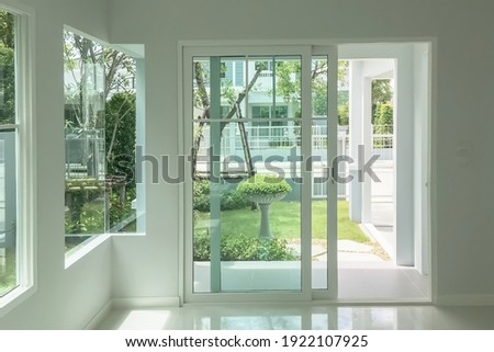 Interior atmosphere minimal style design of empty room show white wall with sliding door and glass windows looking through the outdoor garden.

