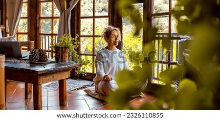 Interior balance and love for yourself concept lifestyle. One middle age youthful woman doing meditation in yoga asana position at home sitting on the floor. Healthy natural exercise. Mental wellbeing
