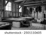 The interior of a barracks at Manzanar with beds and clothes drying on a clothesline.