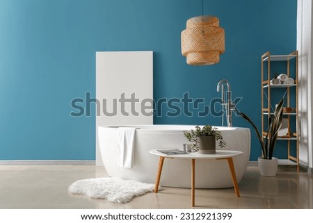 Interior of bathroom with bathtub and houseplant on coffee table