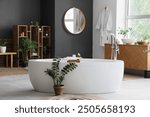 Interior of bathroom with bathtub, shelf unit and plants