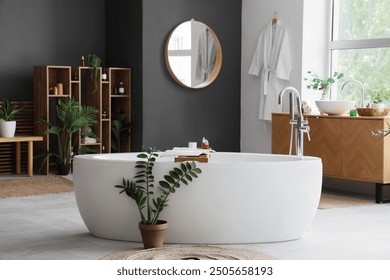 Interior of bathroom with bathtub, shelf unit and plants