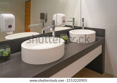 Interior of bathroom with washbasin and faucet. Public bathroom in the airport or restaurant, cafe. Bathroom interior sink with modern design in luxury hotel