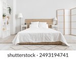 Interior of bedroom with bed, shelving unit and folding screen