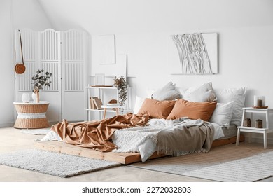 Interior of bedroom with folding screen and creative artwork
