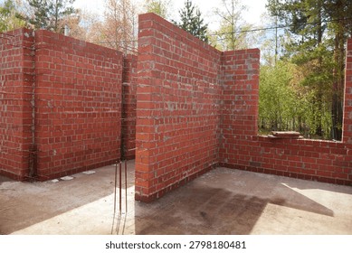 Interior brick structure of a partially built house with open window spaces and unfinished masonry walls. 