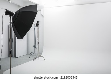 Interior Of Bright Space Of Photo Studio With Large White Cyclorama With Lighting Equipment