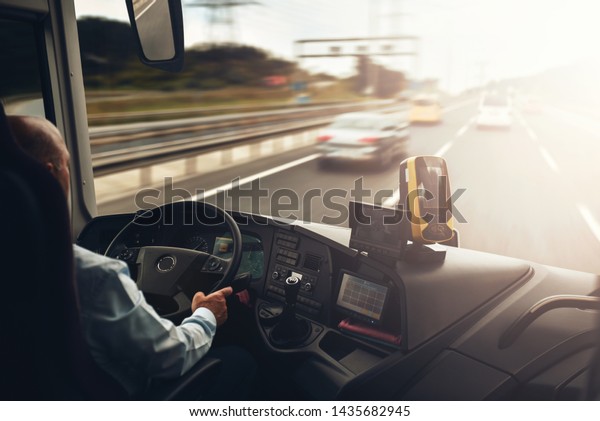 Interior of cab airport transfer bus with driver\
in motion on fast speed by\
highway
