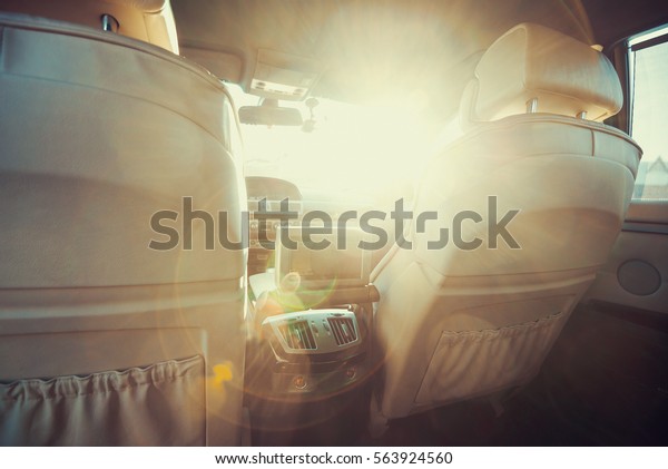 interior of the car behind the\
beautiful white leather seats and a large flare from the\
sun