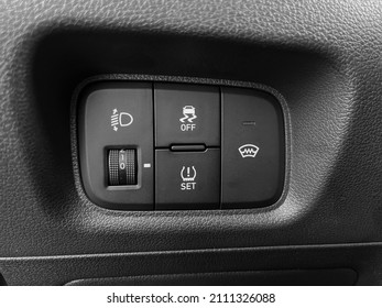 The interior of the car. Buttons for adjusting the height of the headlights, turning off the ESP, turning on the windshield heating. Black and white photo