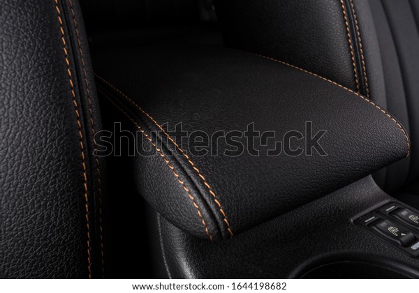the interior of the\
car is covered with handmade genuine leather. Car leather black\
armrest. front view. High-quality stitching with gold threads and\
skin texture are visible