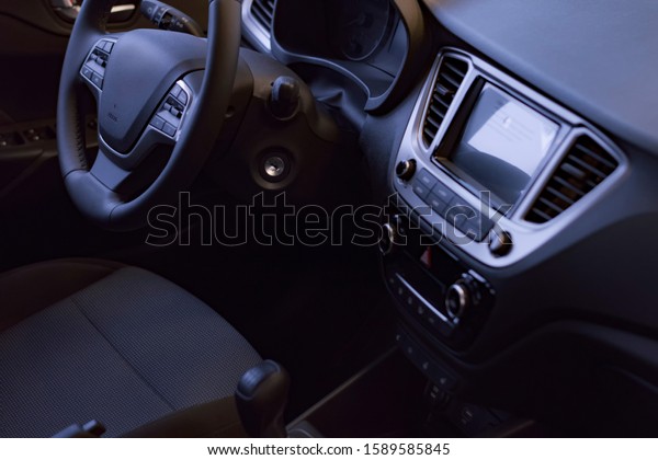 Interior of car. Panel with gear lever for\
transmitting box, dashboard, steering wheel, leather seats and\
armrest. Shot in low key. Soft\
focus.