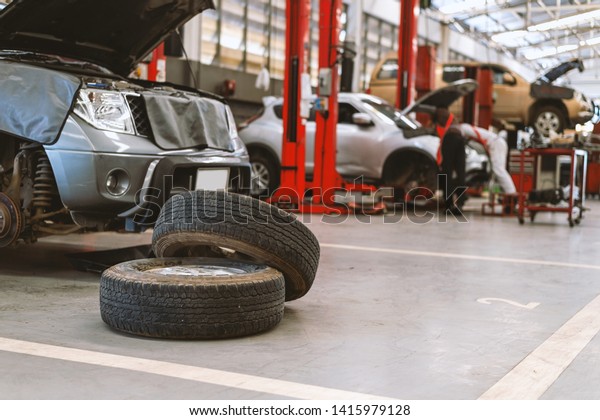 Interior of a car repair in\
garage service station with soft-focus and over light in the\
background