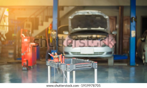 Interior of a car\
repair shop. Car on auto lift in garage for repair and maintenance\
service. Vintage color\
tone