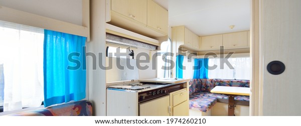 Interior of a caravan trailer. Panoramic view.
Bedroom, dining room, kitchen. Local business concept. Netherlands.
RV, motorhome, transportation, road trip, traveling, ecotourism,
lifestyle, comfort