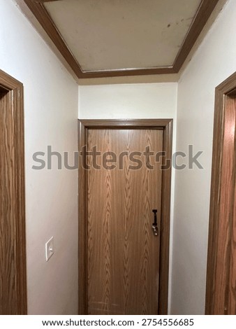 Interior ceiling attic hatch access panel inside residential hallway