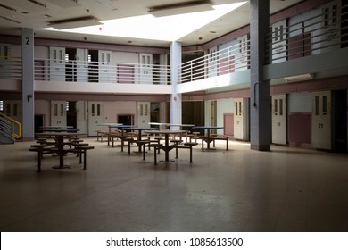 Interior of cell block in abandoned State Correctional Institution, or jail., common room with jail cells.