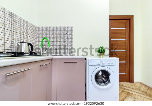Interior of cheap simple kitchen with wooden\
counter and white washing machine. Rostov-on-Don, Russia - 18\
november 2020.
