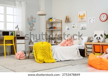 Interior of children's room with bed, study table and toys